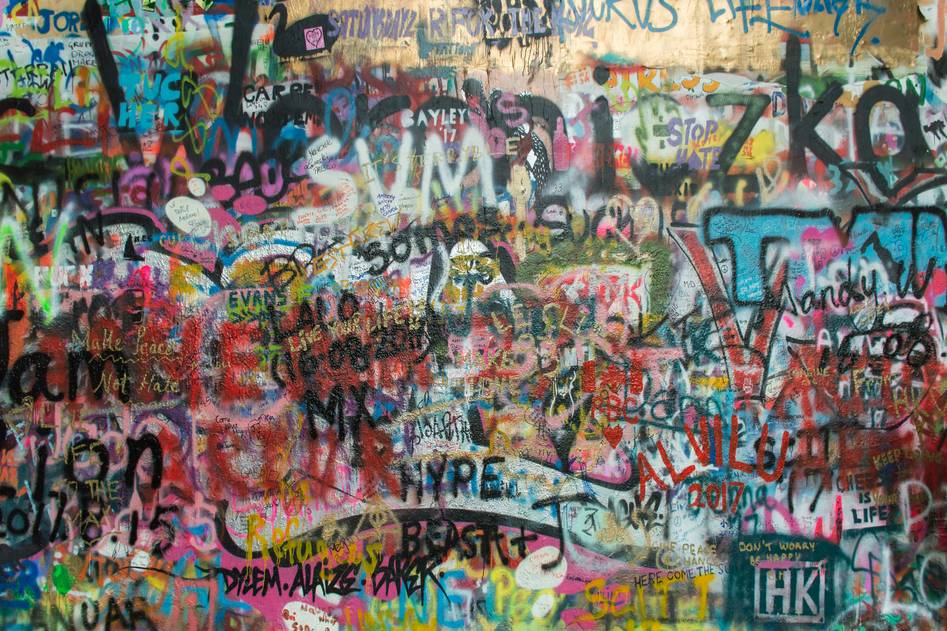 Graffiti-covered car next to a homeowner reviewing vandalism insurance documents with a calm expression